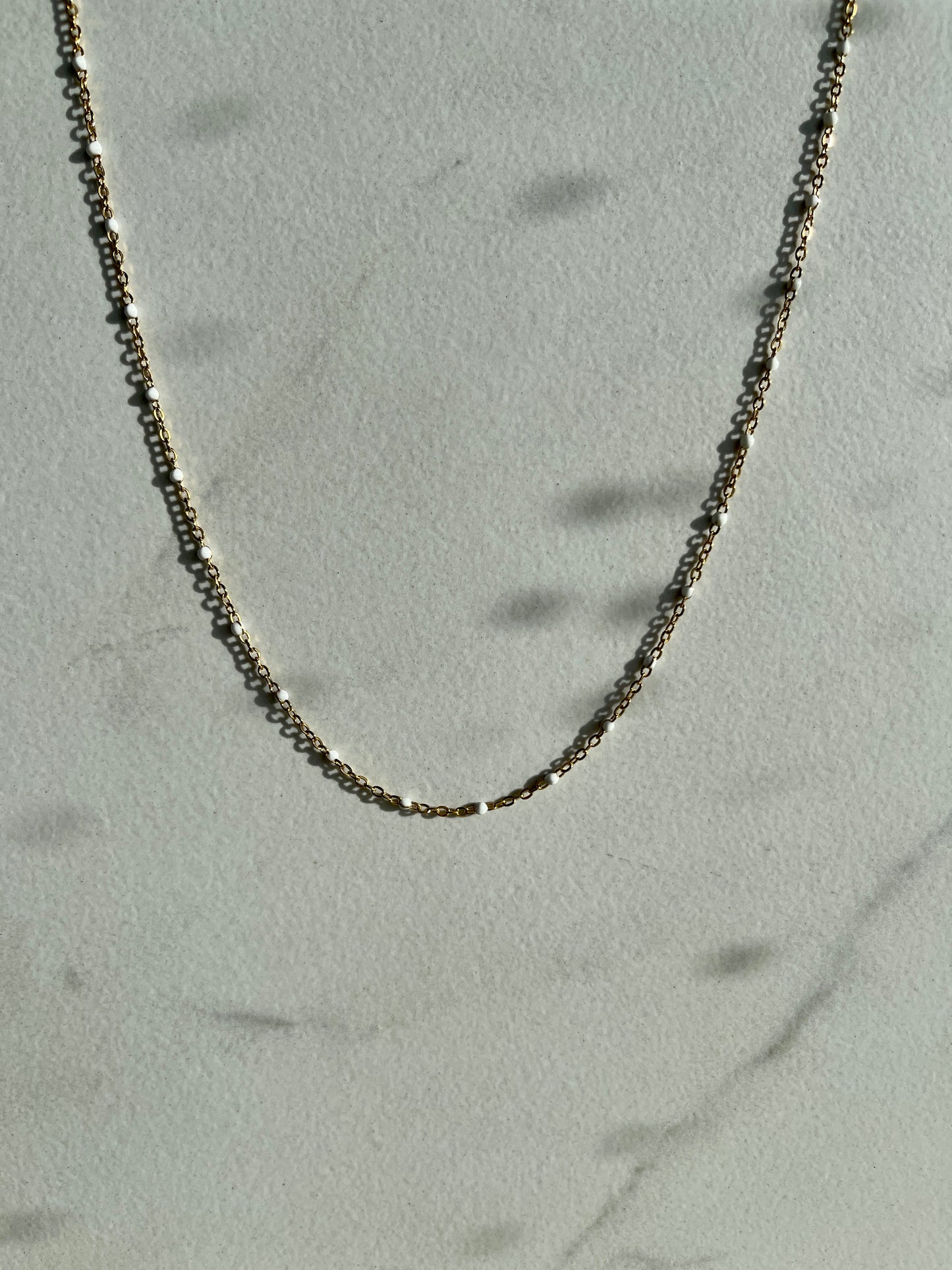 White enamel chain gold 
necklace